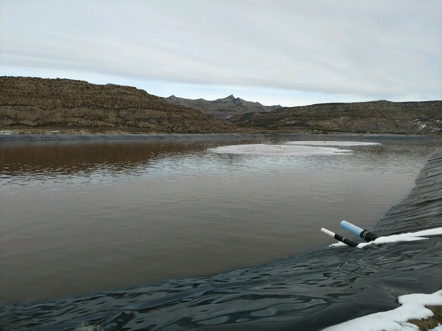 One of Greenleaf's lined evaporation ponds, with the Piceance Basin mesas in the background